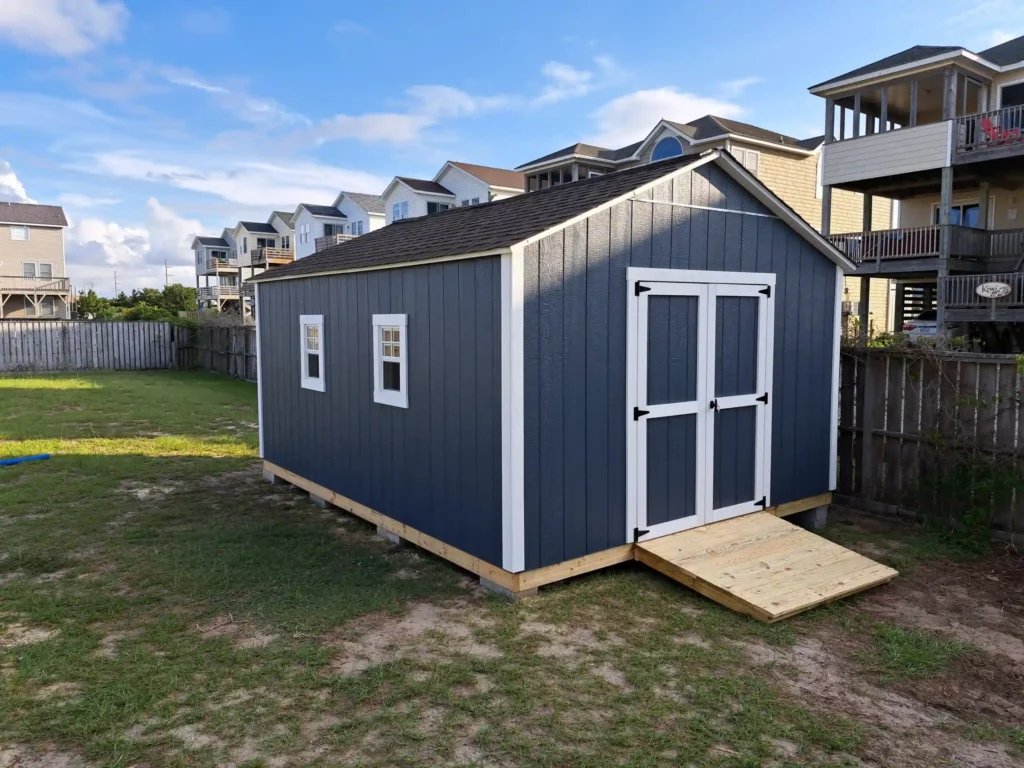 Spacious navy blue utility shed or backyard workshop with white trim, double doors, and two side-entry windows.
