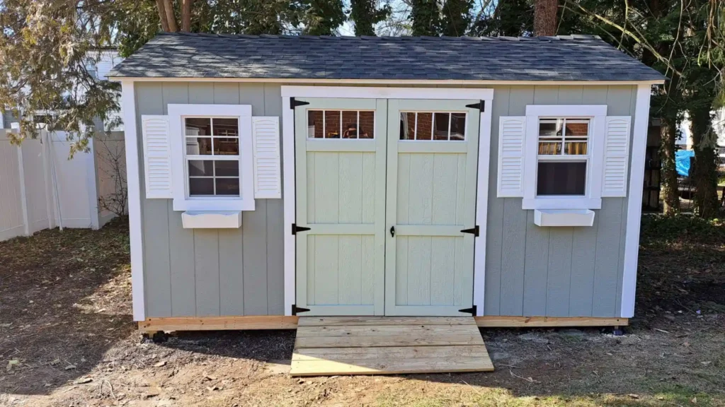 A compact shed with a door and windows, representing the company's expertise in shed and deck construction.
